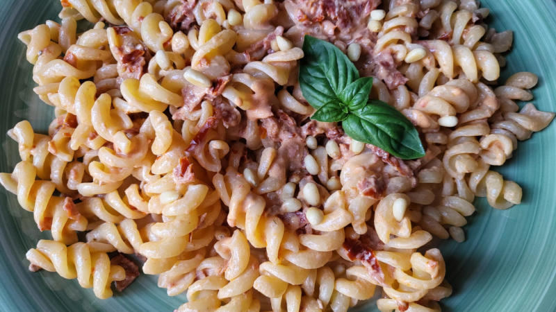 Pasta con pomodori secchi, robiola e pinoli